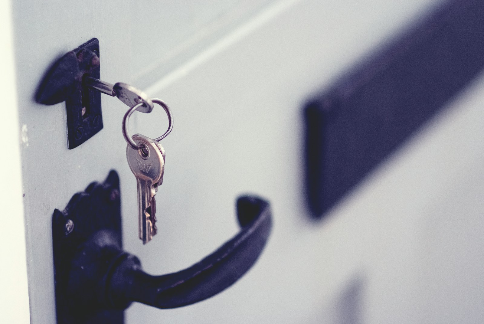 Photo by Jaye Haych black and silver padlock on white door
